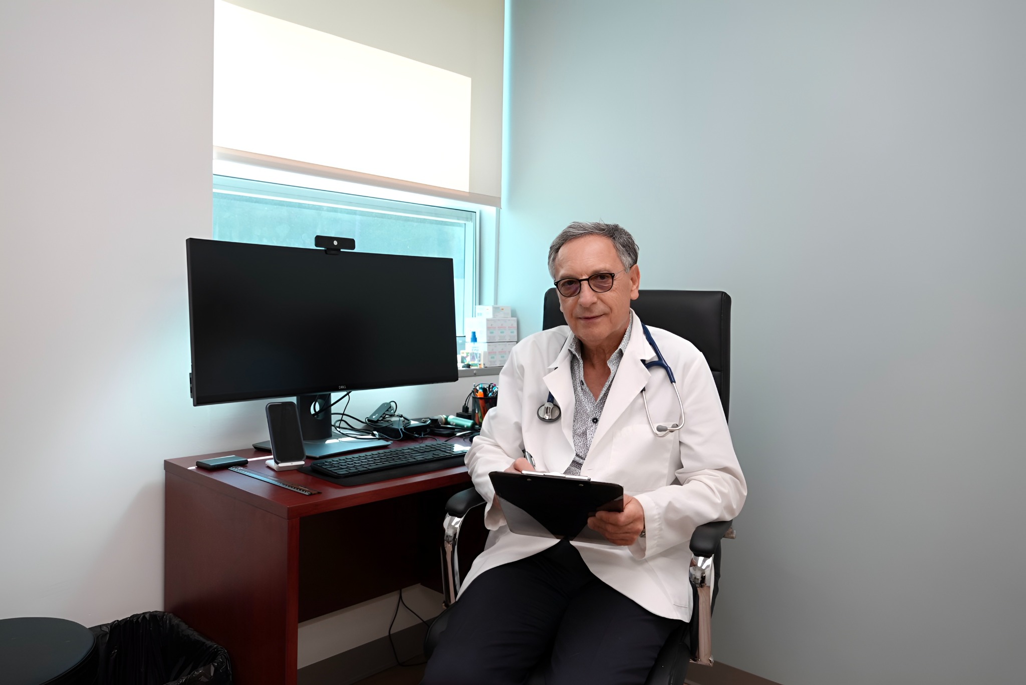 Dr. Alex Czira seated in his Huntington medical office